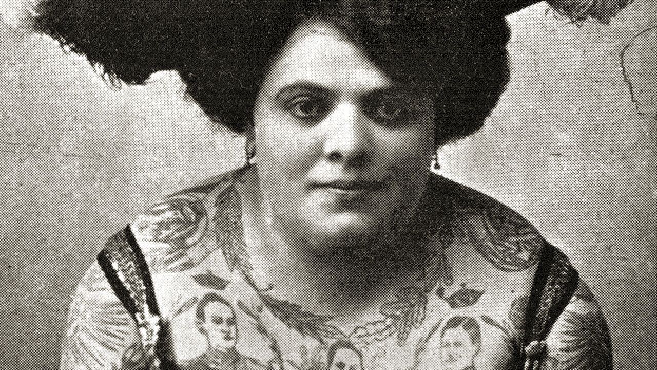 Svartvitt foto på tatuerad kvinna från 1900-talets början.